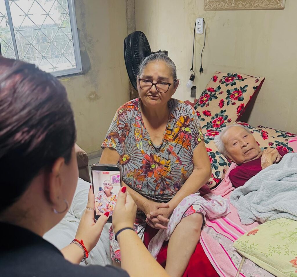 Imagem da Lucila sentada na cama ao lado de José Ivo, enquanto é entrevistada para a matéria