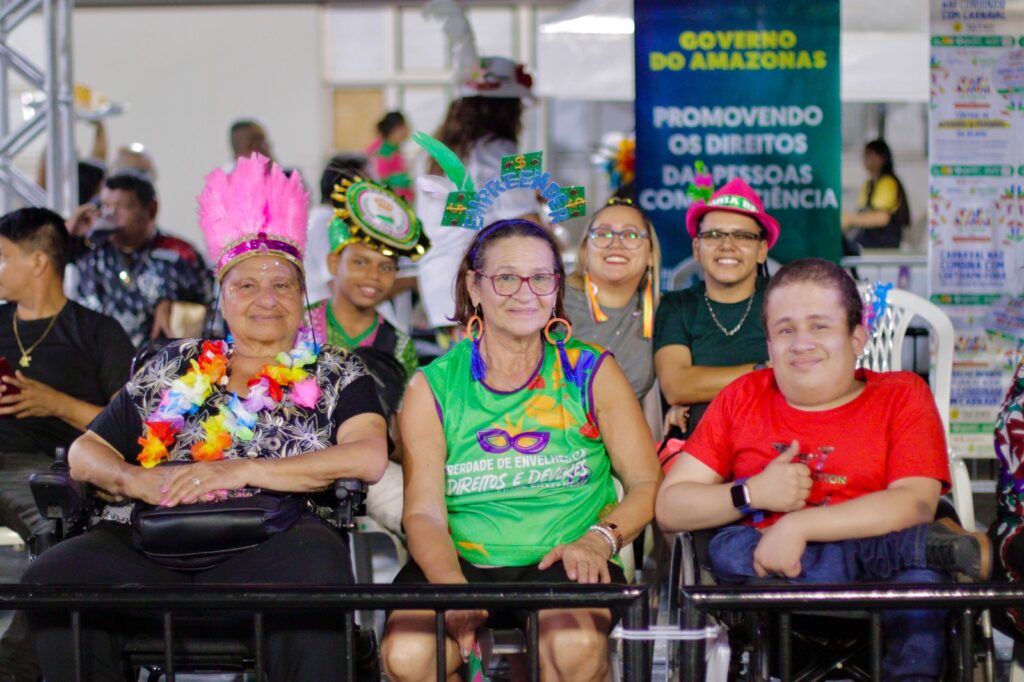 Imagem de pessoas com deficiência e idosos sorrindo, fantasiados, no espaço acessivel 