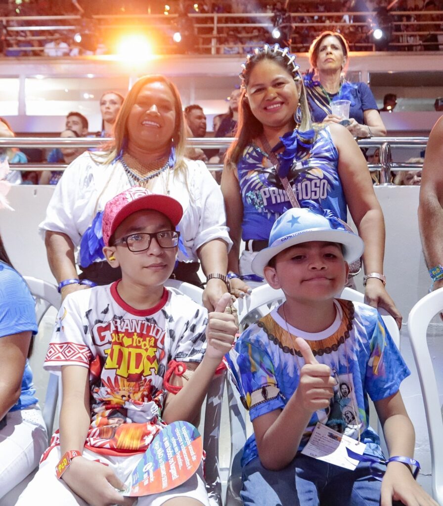 imagem de uma família com duas mães e dois filhos, um vestido de azul e outro de vermelho