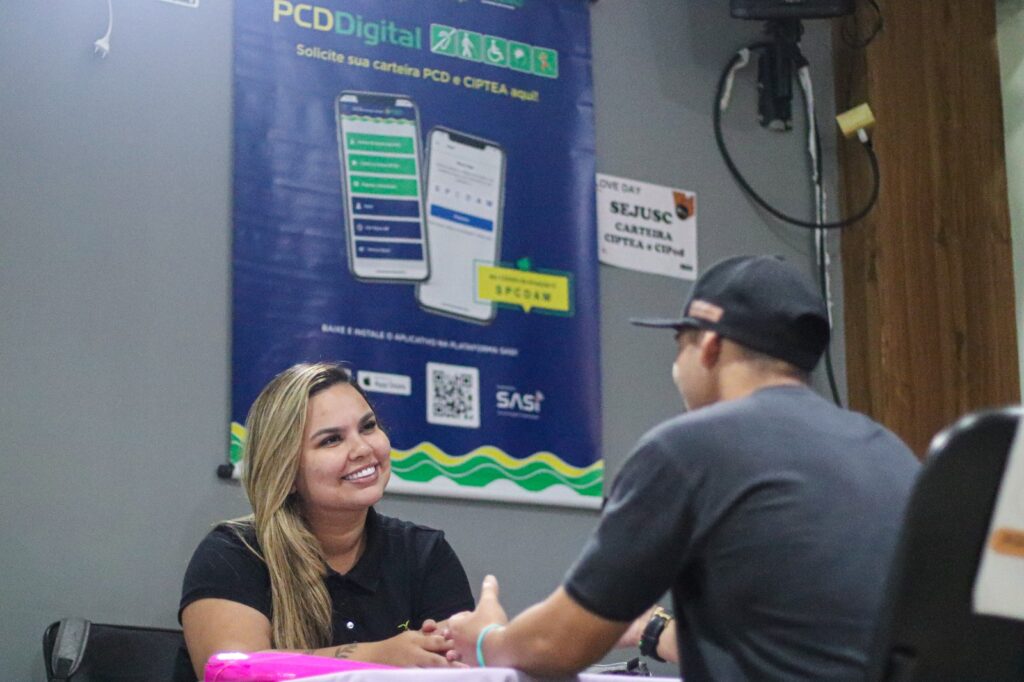 imagem da servidora sorrindo enquanto atende uma pessoa e orienta sobre a cipcd