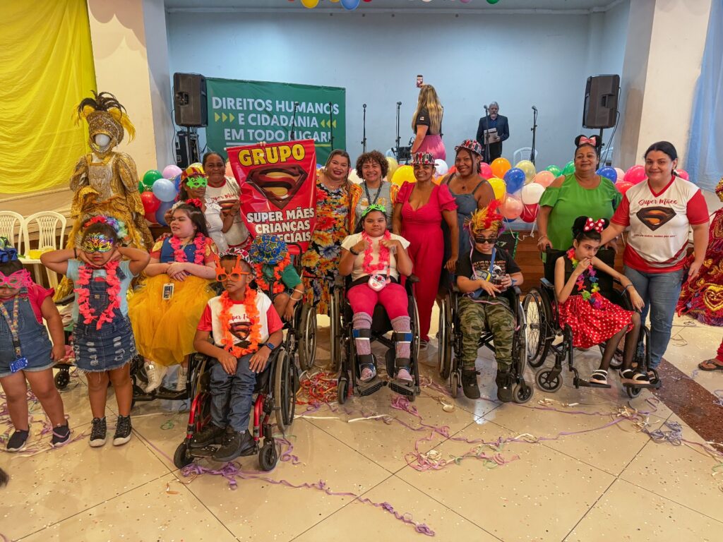 Imagem de diversos pcds sorrindo, fantasiados e felizes no baile inclusivo