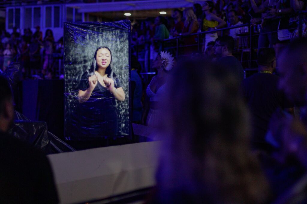 imagem de uma intérprete de libras aparecendo na imagem de uma tv no espaço acessivel