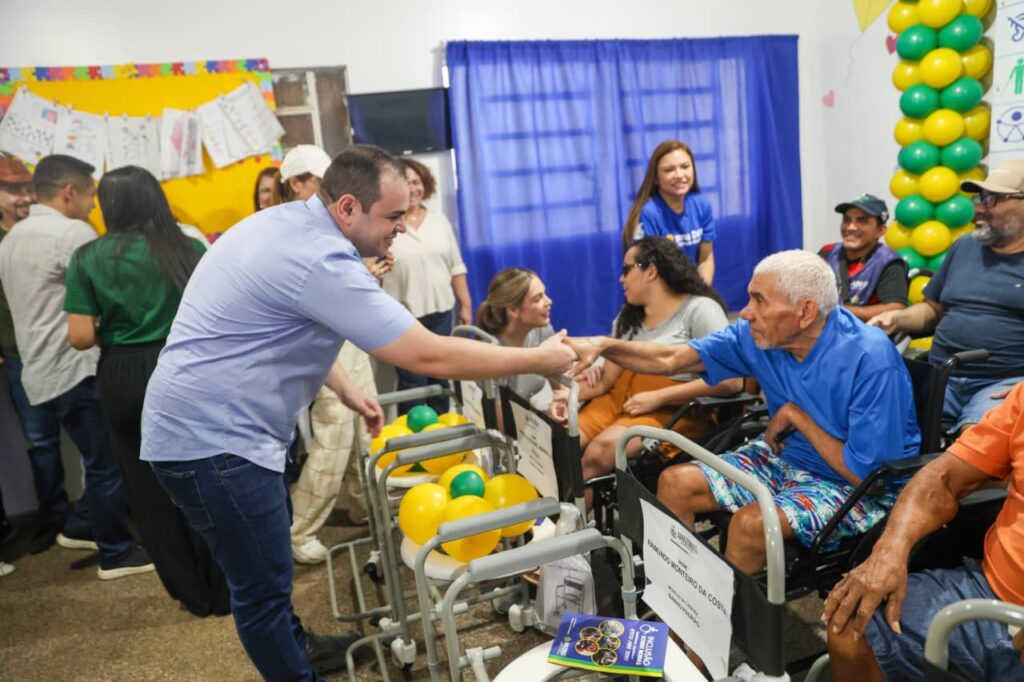governador roberto cidade apertando a mão de um senhor em cadeira de rodas